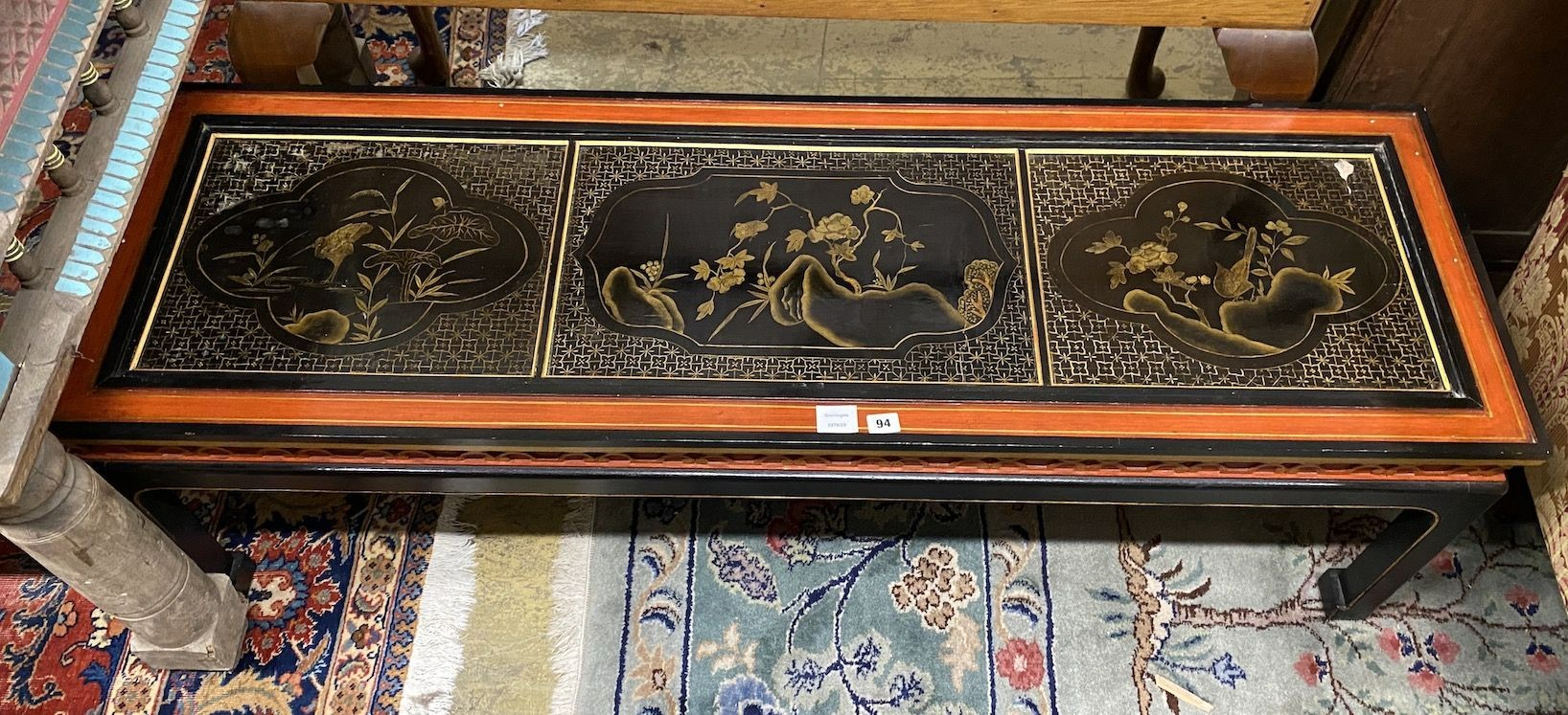 A Chinese black and red lacquered coffee table, the top inset three 18th century lacquer panels, length 138cm, depth 47cm, height 45cm